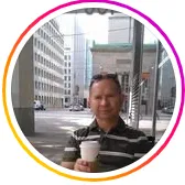Man holding a coffee with the city in the background